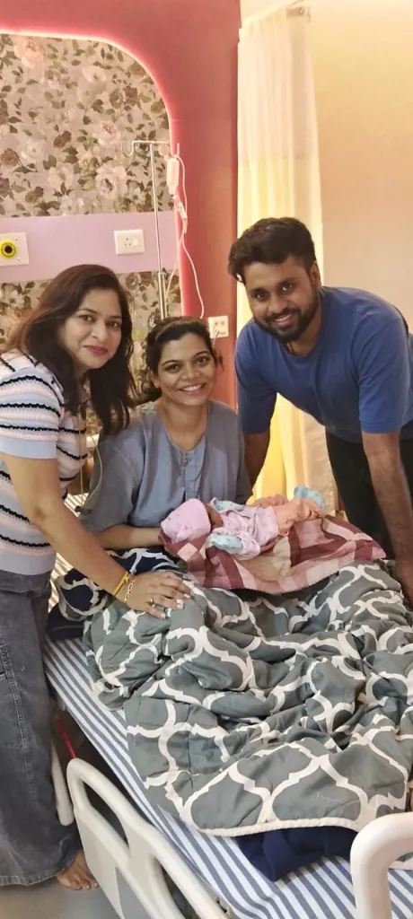Dr. Poonam celebrating a successful newborn delivery with parents in the recovery room